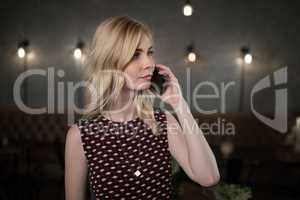 Woman talking on mobile phone in restaurant