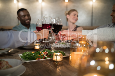 Friends toasting red wine in restaurant