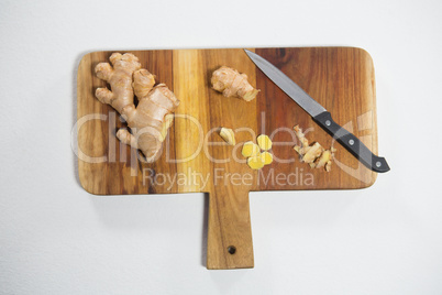 Overhead view of ginger and knife on cutting board
