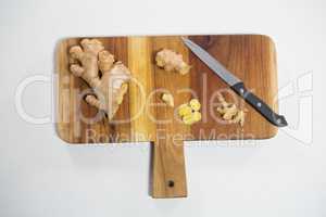 Overhead view of ginger and knife on cutting board