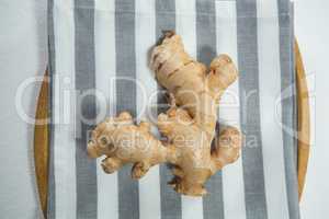 Directly above view of fresh ginger on striped napkin in plate