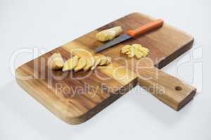 High angle view of fresh chopped gingers with knife on wooden cutting board