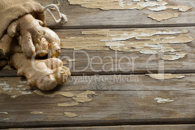 Close up of fresh gingers and burlap on weathered table