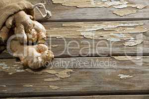 Close up of fresh gingers and burlap on weathered table