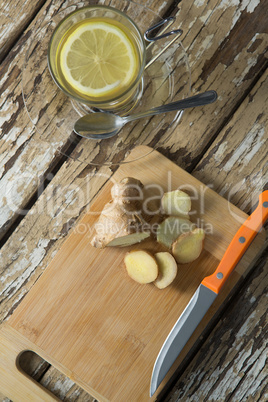 Directly above view of gingers on cutting board by tea over weathered table