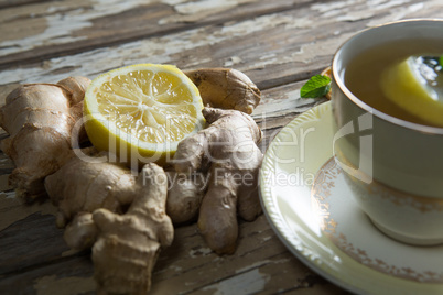 Close up of lemon amidst gingers by tea on table