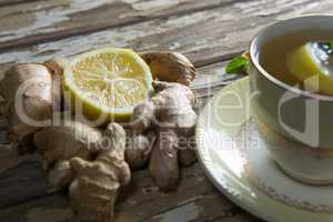 Close up of lemon amidst gingers by tea on table
