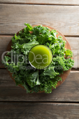 Juice in glass with fresh kale on table