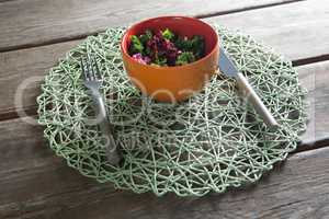 Vegetable salad in bowl on place mat at table