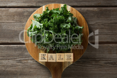 Kale leaves with text blocks on cutting board