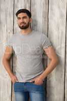 Handsome man posing against wooden background