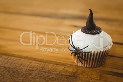 Cup cake with spider and witch hat on table