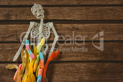 View of skeleton decoration with candies on table