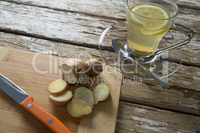 High angle view of gingers on cutting board by tea over weathered table