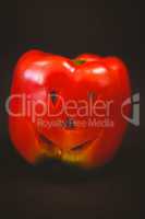 Carved red bell pepper over black background