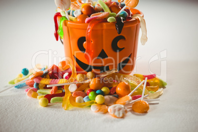 Orange bucket with various sweet food during Halloween