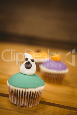 Cup cake with ghost on wooden table during Halloween