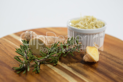 Close up of ginger and rosemary on wooden serving board