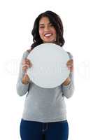 Smiling woman holding circle shaped placard
