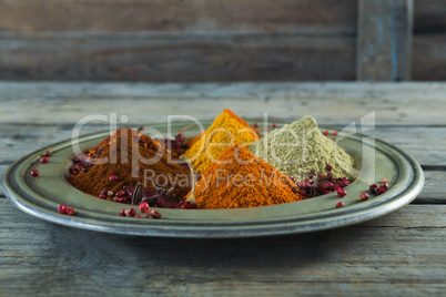 Various type of spices in plate on wooden table