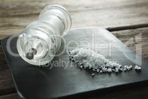 Salt shaker and salt on black slate plate