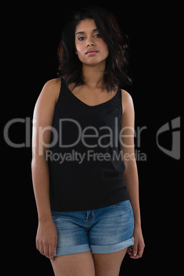 Young woman standing against black background