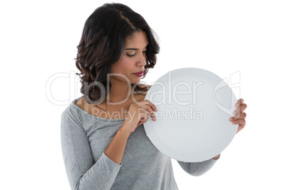 Young woman holding circle shaped placard