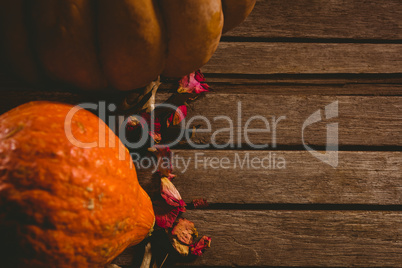 Pumpkins and petals on wooden table