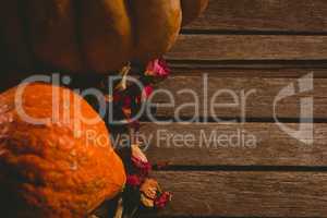 Pumpkins and petals on wooden table