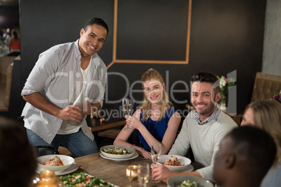 Happy friends dinging together in restaurant