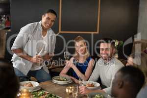 Happy friends dinging together in restaurant