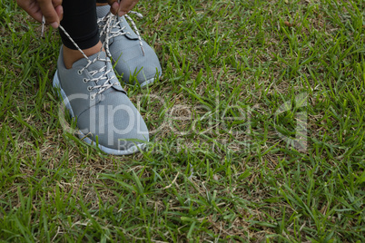 Athlete tying shoelace on field