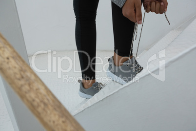 Female athlete tying shoelace on steps