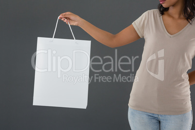 Mid section of woman holding shopping bag
