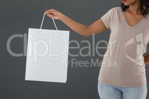 Mid section of woman holding shopping bag