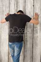 Man leaning on wooden wall