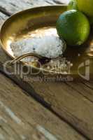 Lemon and salt in plate on wooden table
