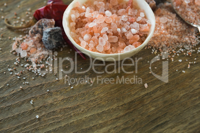 Himalayan salt with spices on wooden table