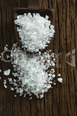 Salt in spoon on wooden table