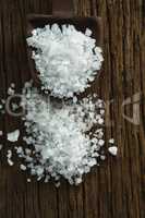 Salt in spoon on wooden table
