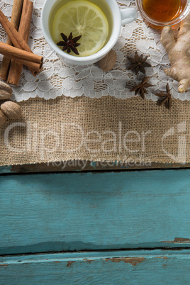 Overhead view of ginger tea with honey and cinnamons on burlap
