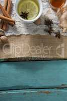 Overhead view of ginger tea with honey and cinnamons on burlap