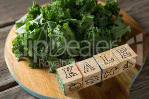 Fresh kale leaves with text on cutting board
