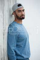 Man leaning on wooden wall