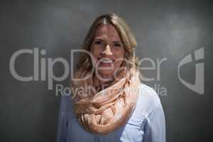 Portrait of beautiful woman smiling against grey background