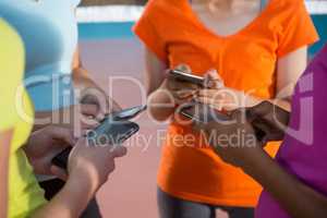 Female players using mobile phones in volleyball court