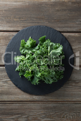 Overhead view of fresh kale on plate over table