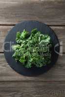 Overhead view of fresh kale on plate over table