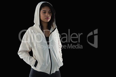 Thoughtful female athlete in hooded jacket