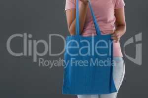 Mid section of woman holding blue shoulder bag